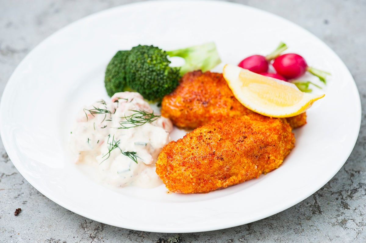 Panerad fisk serverad med broccoli, citron, rädisor och kall sås
